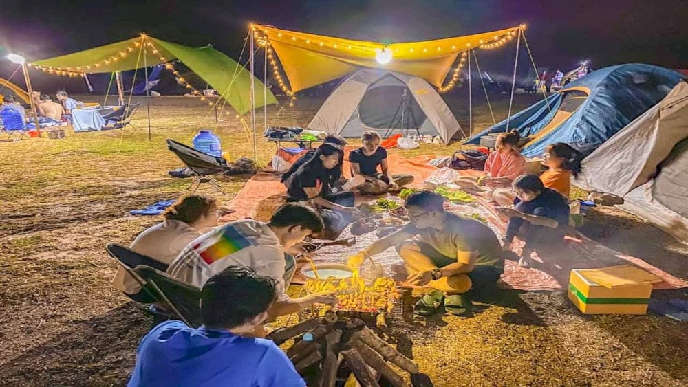 Nhóm bạn mở tiệc nướng quanh khu cắm trại ven hồ
